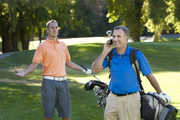 A golfer takes a cell phone call while his fellow golfer asks him to get off his phone and just play