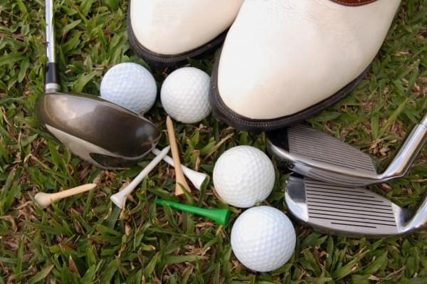 Golf shoes and equipment on the grass