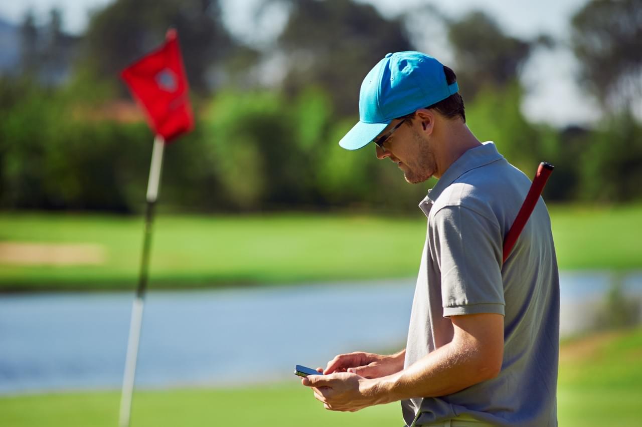 modern golf man with smart phone taking score on mobile gps devi