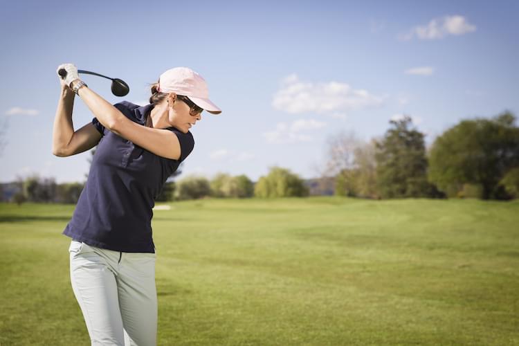 Close up of woman golf player swinging golf club