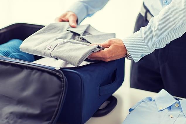 bigstock-businessman-packing-clothes-in-113936240